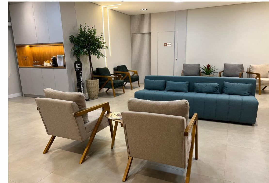 Sala de espera ampla com poltronas e plantas